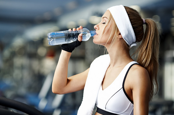 девушка пьёт воду на тренировке